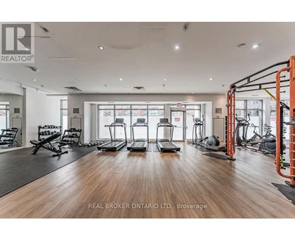 A gym with a variety of equipment including treadmills, weights, and exercise machines.