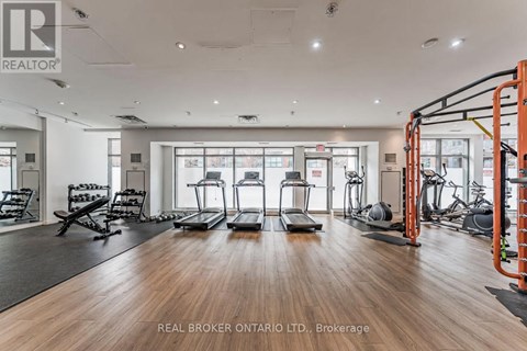 A gym with a variety of equipment including treadmills, weights, and exercise machines.