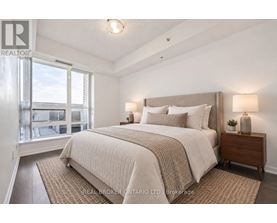 A bedroom with a large bed and a window overlooking a balcony.