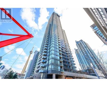 A tall building with many windows stands in front of other buildings.