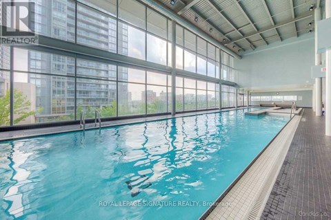 A large indoor swimming pool with a glass wall on one side.