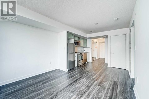 A spacious room with wooden flooring and white walls.
