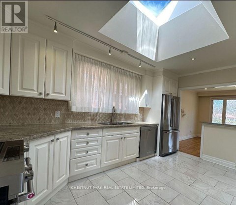 A kitchen with white cabinets and a marble countertop.