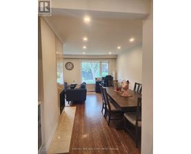 A dining room with a wooden table and chairs.
