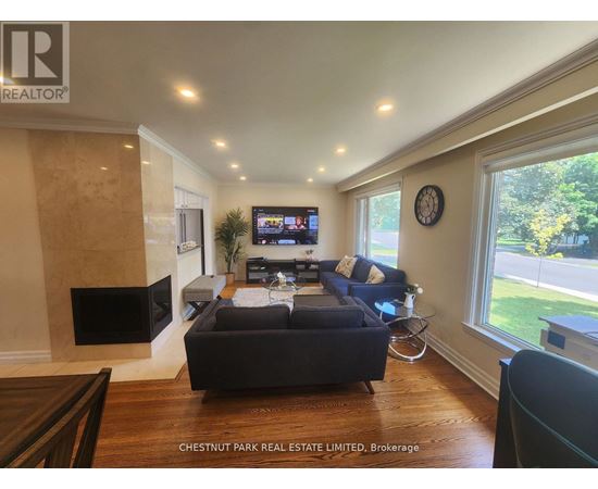 A living room with a dark sofa and a flat screen TV.