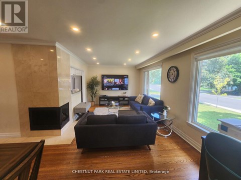 A living room with a dark sofa and a flat screen TV.