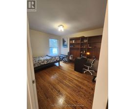 A bedroom with a bed, desk, and chair.