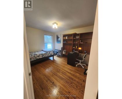 A bedroom with a bed, desk, and chair.