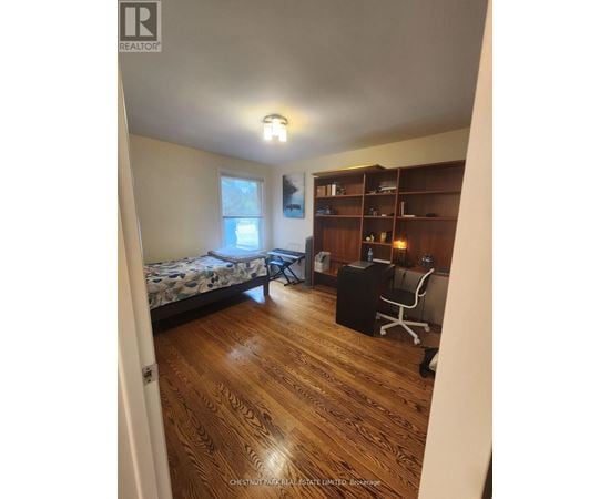A bedroom with a bed, desk, and chair.