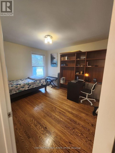 A bedroom with a bed, desk, and chair.