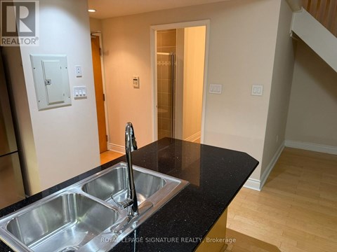 A modern kitchen with a sink and a stainless steel faucet.