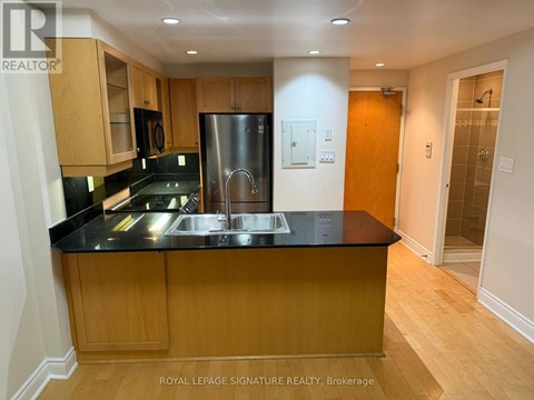 A kitchen with wooden cabinets and a black countertop.