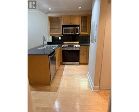A kitchen with wooden cabinets and black appliances.
