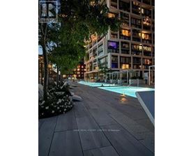 A pool in a city setting surrounded by buildings.
