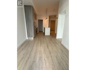 A room with wooden flooring and white walls.