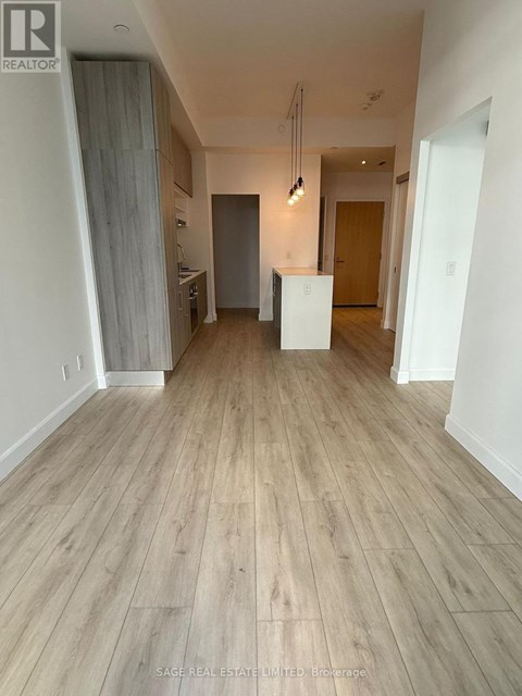 A room with wooden flooring and white walls.
