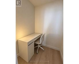 A white desk with a drawer and a chair in a room.