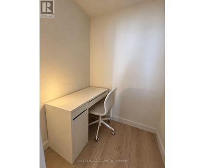 A white desk with a drawer and a chair in a room.