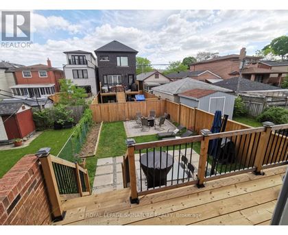 A backyard with a deck and a hot tub.