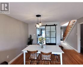 A dining room with a white table and chairs.