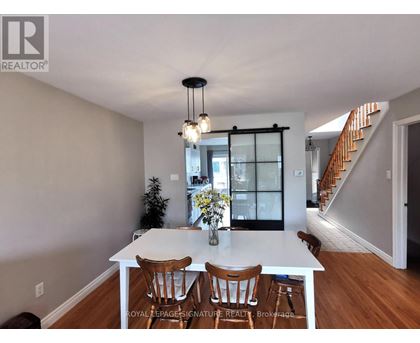 A dining room with a white table and chairs.