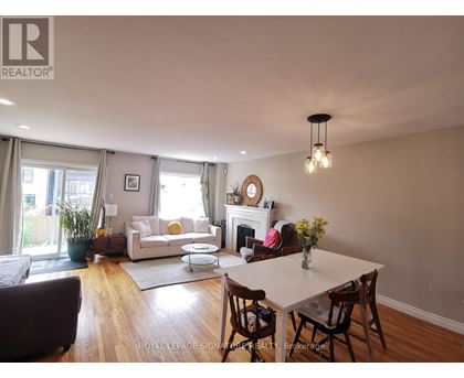 A well-lit living room with a fireplace and a dining table set for four.
