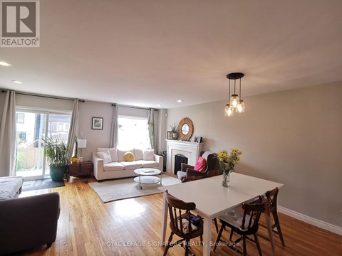 A well-lit living room with a fireplace and a dining table set for four.
