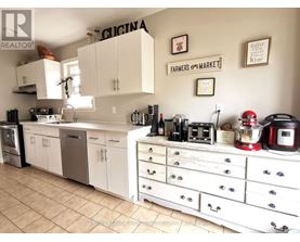 A kitchen with white cabinets and a tile floor.
