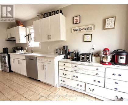 A kitchen with white cabinets and a tile floor.