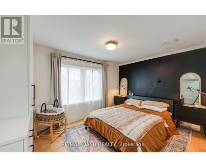 A bedroom with a bed, nightstand, and chair.