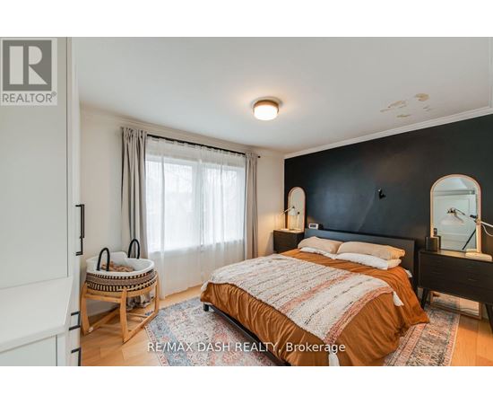 A bedroom with a bed, nightstand, and chair.