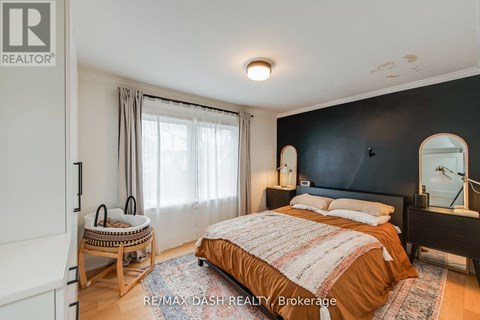 A bedroom with a bed, nightstand, and chair.