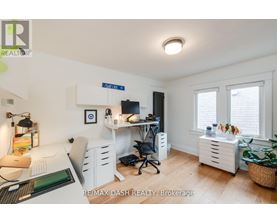 A well-lit office space with a desk, chairs, and a computer setup.