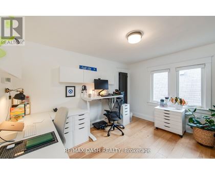 A well-lit office space with a desk, chairs, and a computer setup.
