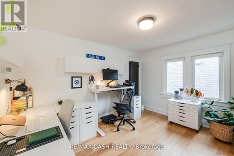 A well-lit office space with a desk, chairs, and a computer setup.