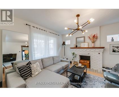 A living room with a grey couch and a fireplace.