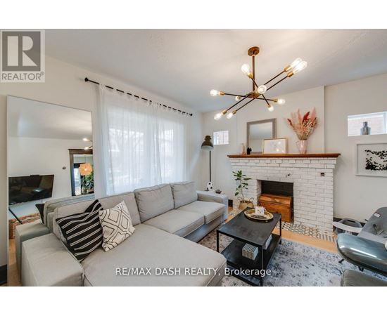 A living room with a grey couch and a fireplace.