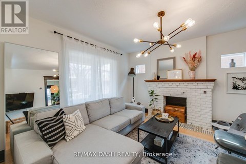 A living room with a grey couch and a fireplace.