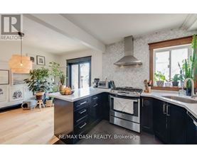 A modern kitchen with a stainless steel oven and black cabinets.
