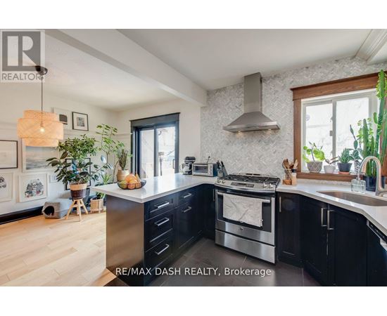 A modern kitchen with a stainless steel oven and black cabinets.