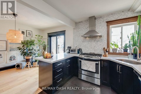 A modern kitchen with a stainless steel oven and black cabinets.