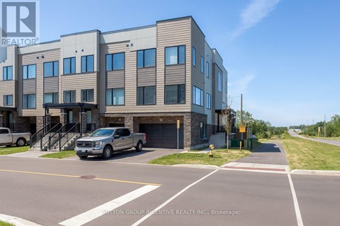A modern building with a realtor sign in front.
