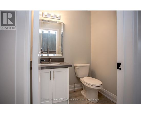 A white toilet in a bathroom with a mirror above the sink.