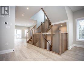 A spacious room with a wooden staircase and a skylight.