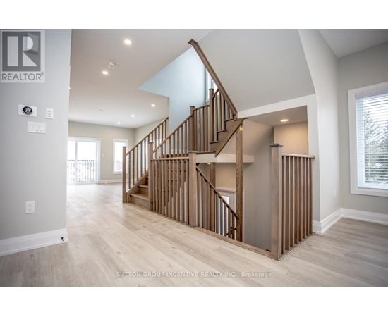 A spacious room with a wooden staircase and a skylight.