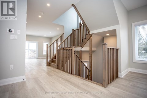 A spacious room with a wooden staircase and a skylight.