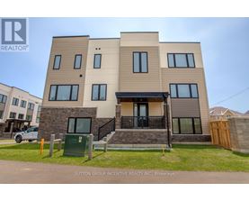 A modern two-story residential building with a balcony and a garage door.