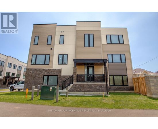A modern two-story residential building with a balcony and a garage door.
