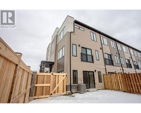 A modern two-story residential building with a wooden fence in front.