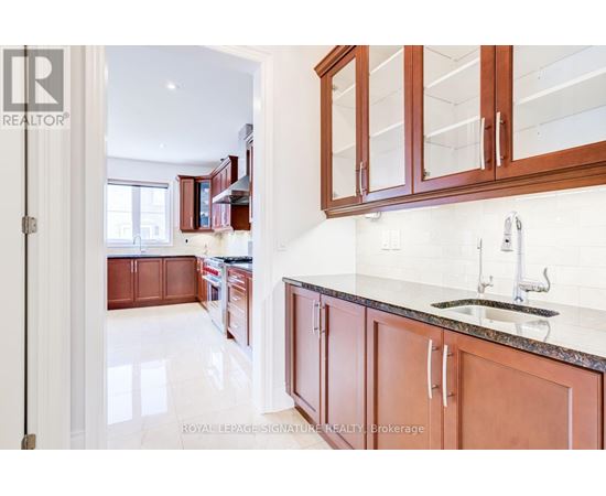 A kitchen with brown cabinets and a marble countertop.